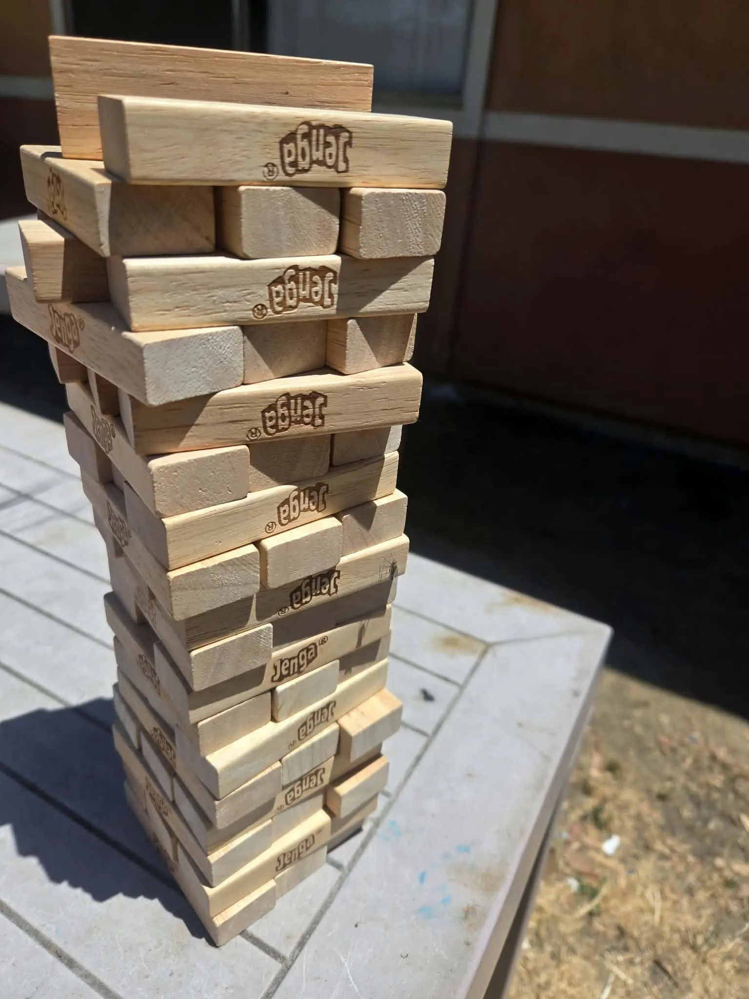 Neighbors gathered around a Jenga game on the CityHeART patio