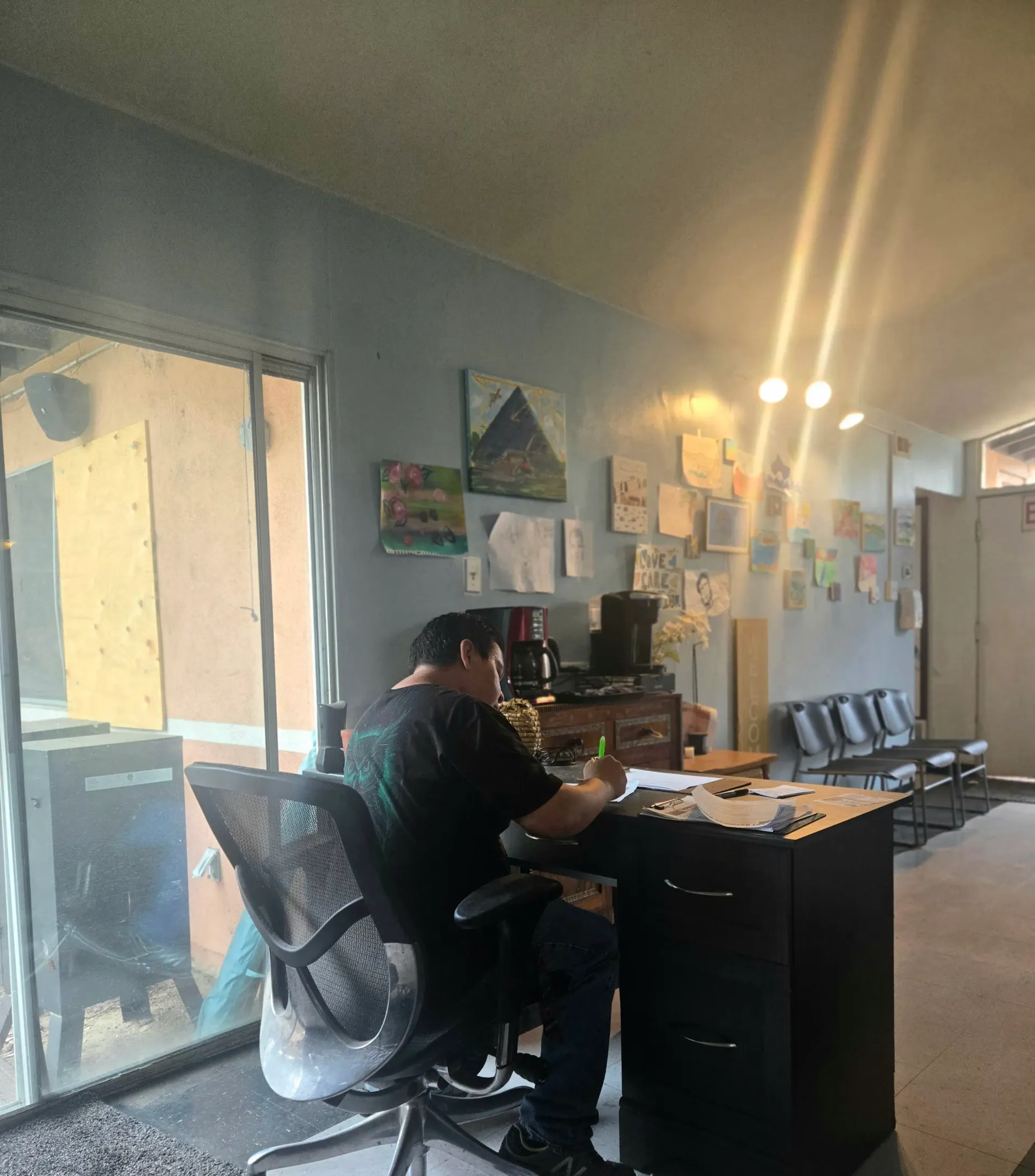 A neighbor writing at the CityHeART Resource Hub intake desk